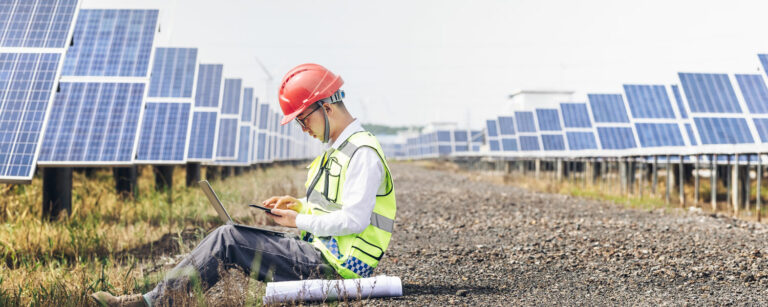 lone worker sitting with a laptop wearing high visibility gear